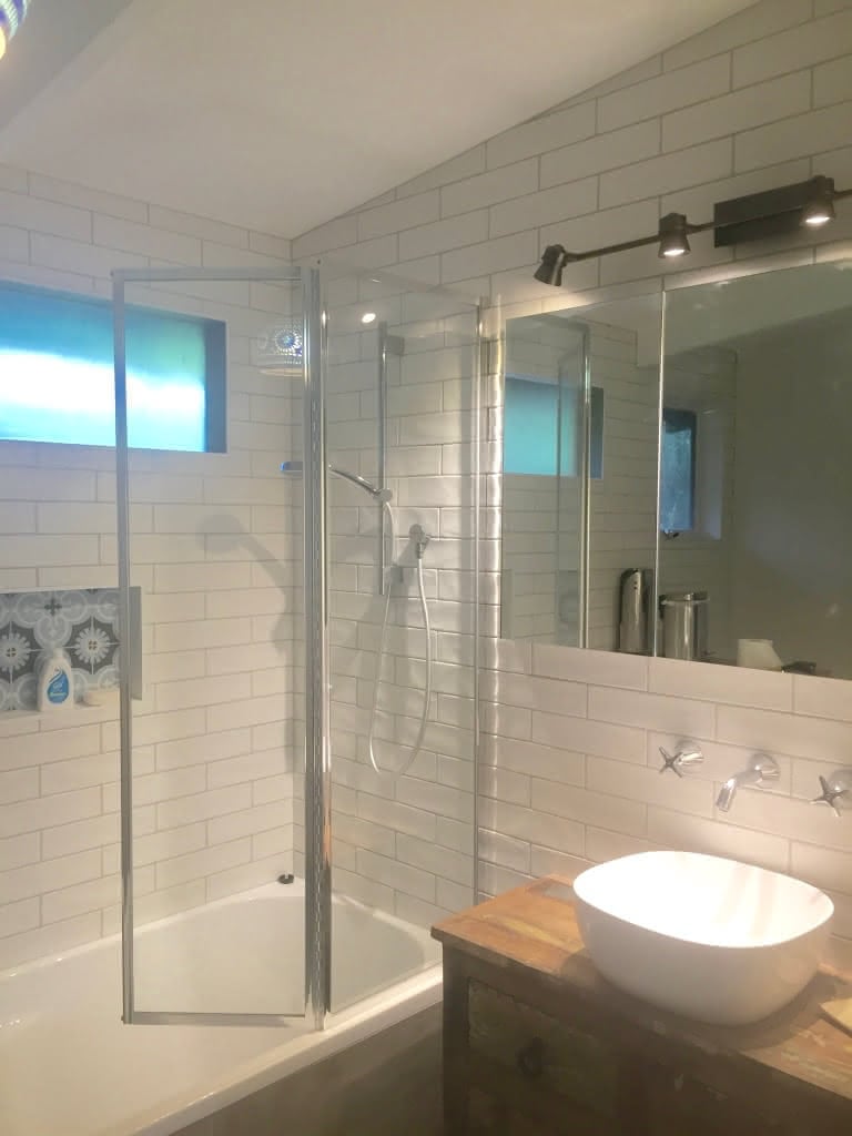 Hinged shower screen over bathtub
